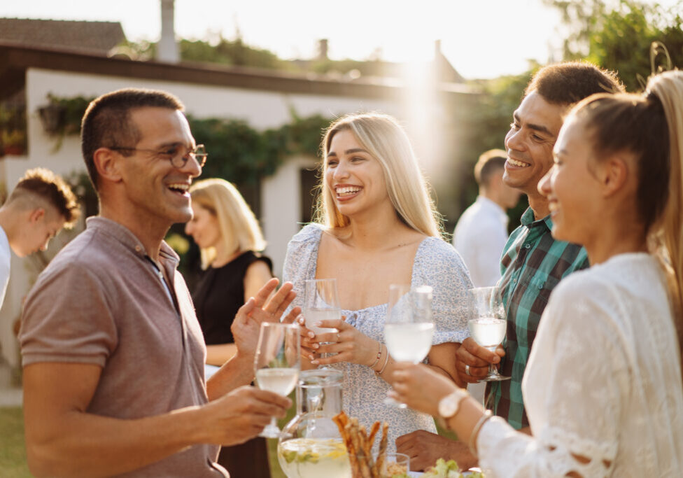 Group of diverse people enjoying summer afternoon and evening in garden party